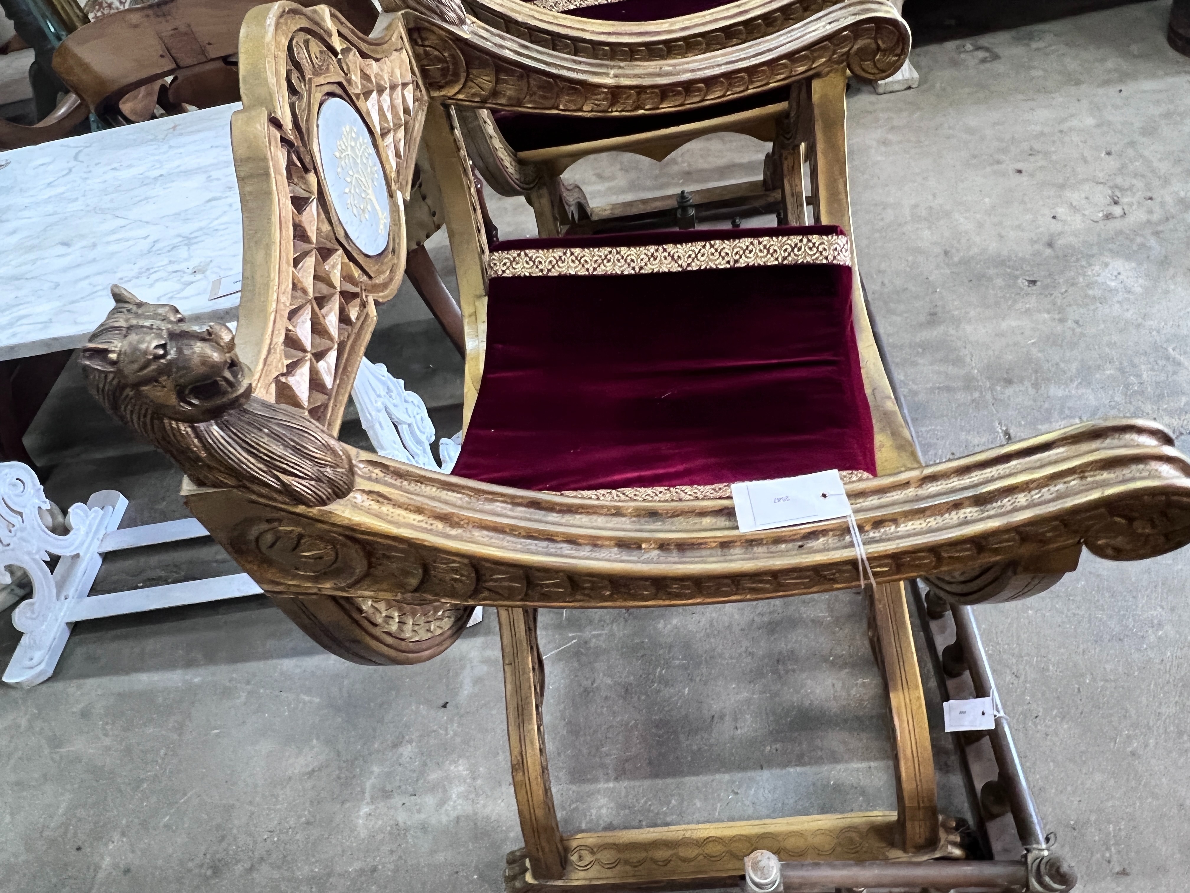A pair of Renaissance style giltwood and composition X frame elbow chairs, on lion's paw feet, width 73cm, depth 59cm, height 99cm